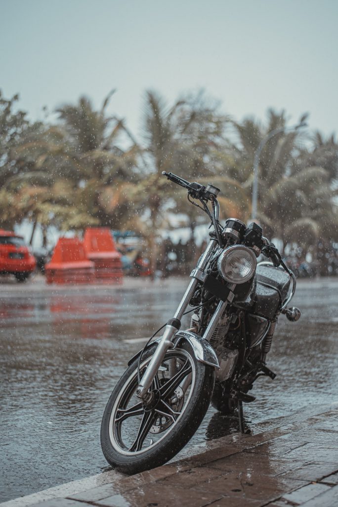 black motorcycle parked beside the body of water during daytime